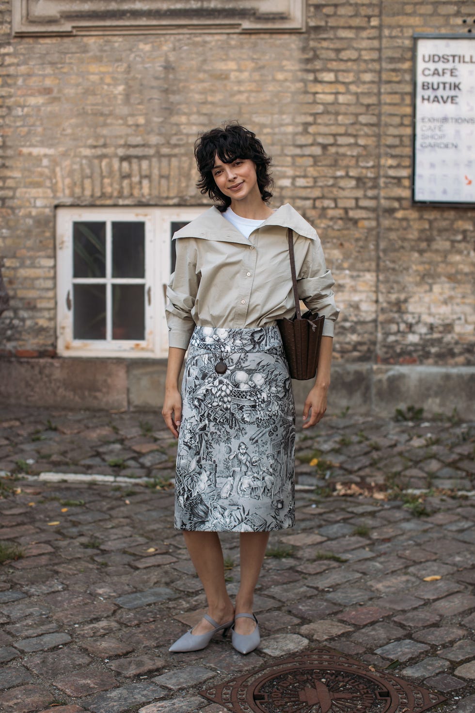 a person standing in a casual outfit in an outdoor setting bob haircuts copenhagen fashion week