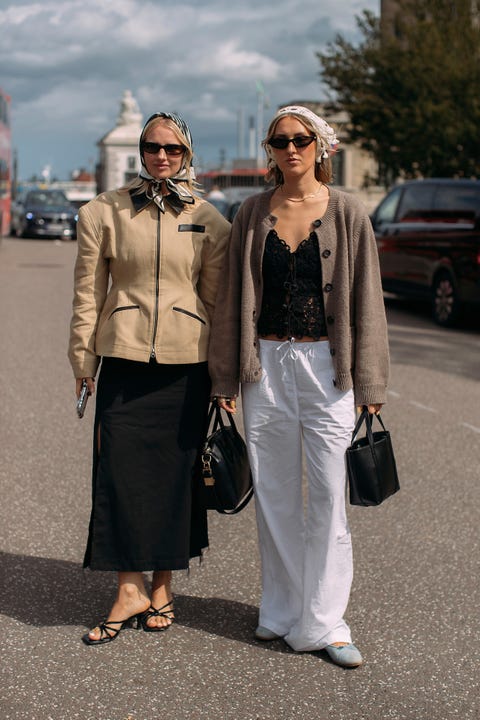Two individuals standing on a city street showcasing contemporary fashion