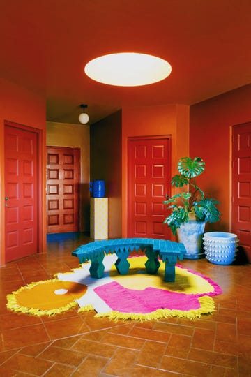 colourful mexican interior with red walls and pink and yellow rug