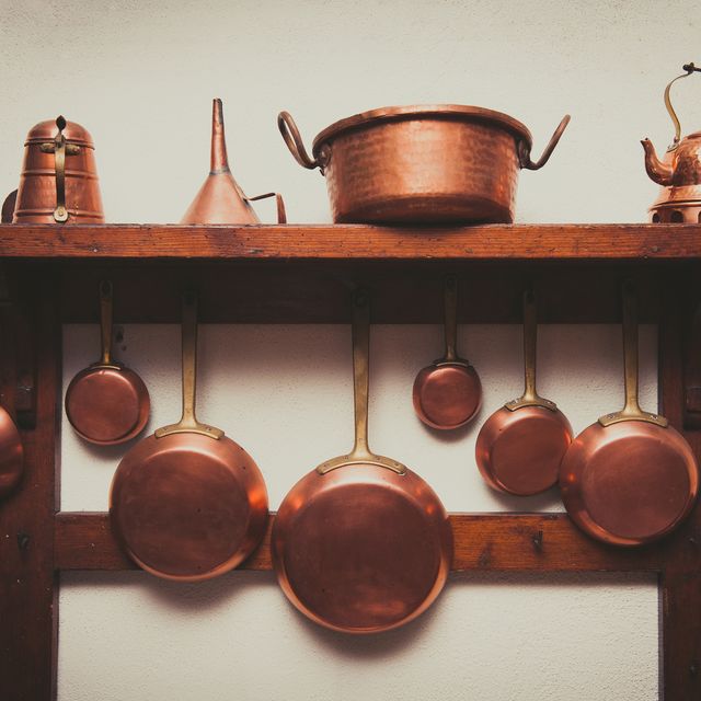 Copper Kitchen Utensils Arranged On Shelf In Kitchen