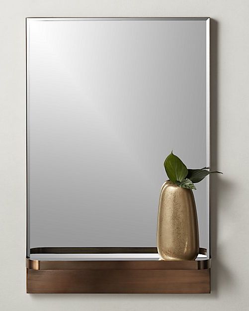 copper mirror with metallic vase on storage