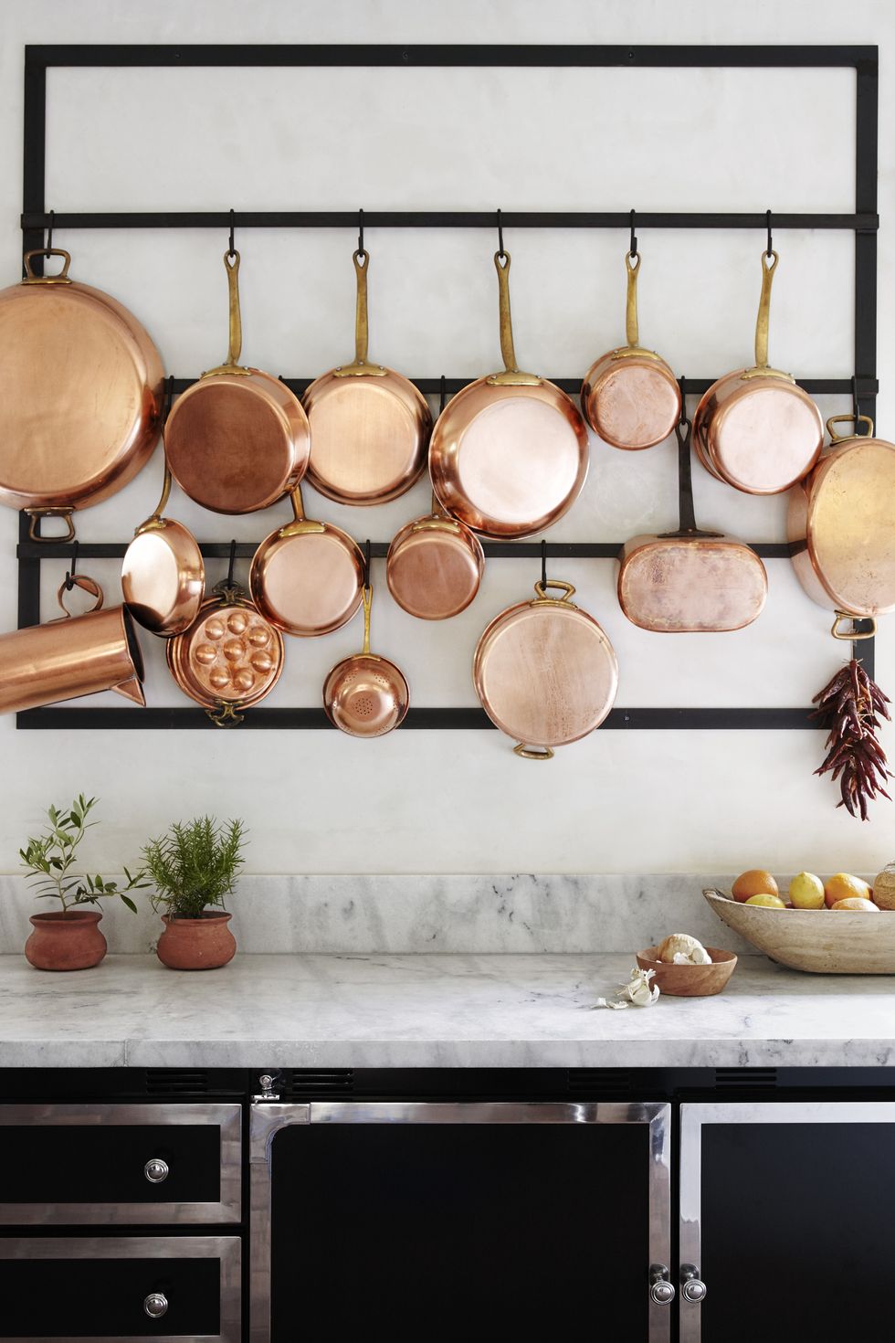copper pots and pans hung on wall