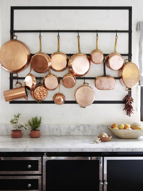 copper pots and pans hung on wall