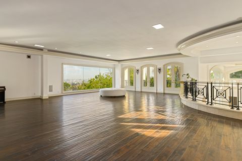 spacious room with wood floors and large windows
