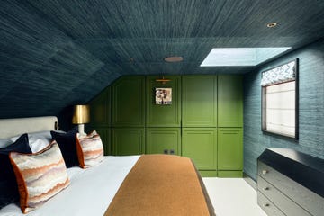 bedroom with blue wallpaper on walls and ceiling and green builtin wardrobes