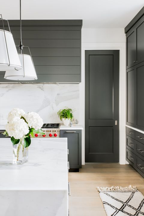 a kitchen with white counters and black cabinets
