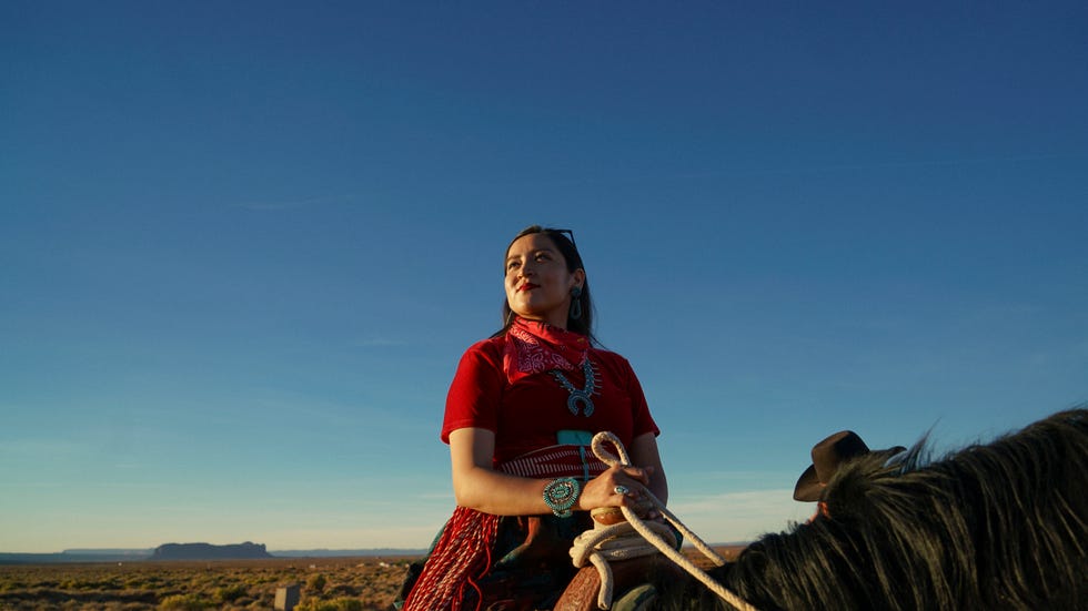 person on horseback wearing traditional attire in a desert setting