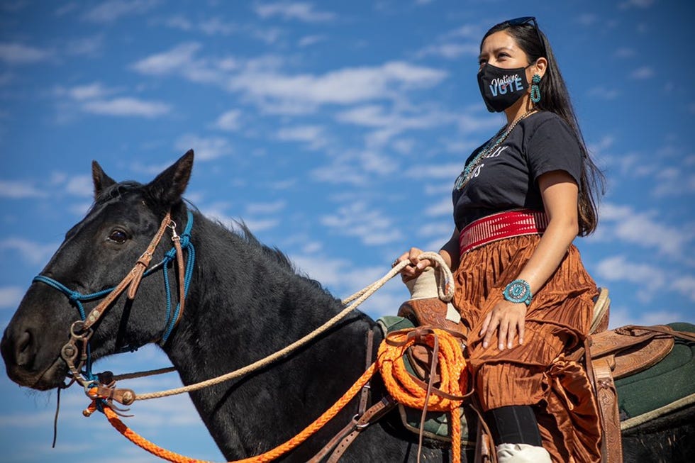 person riding a horse against a blue sky