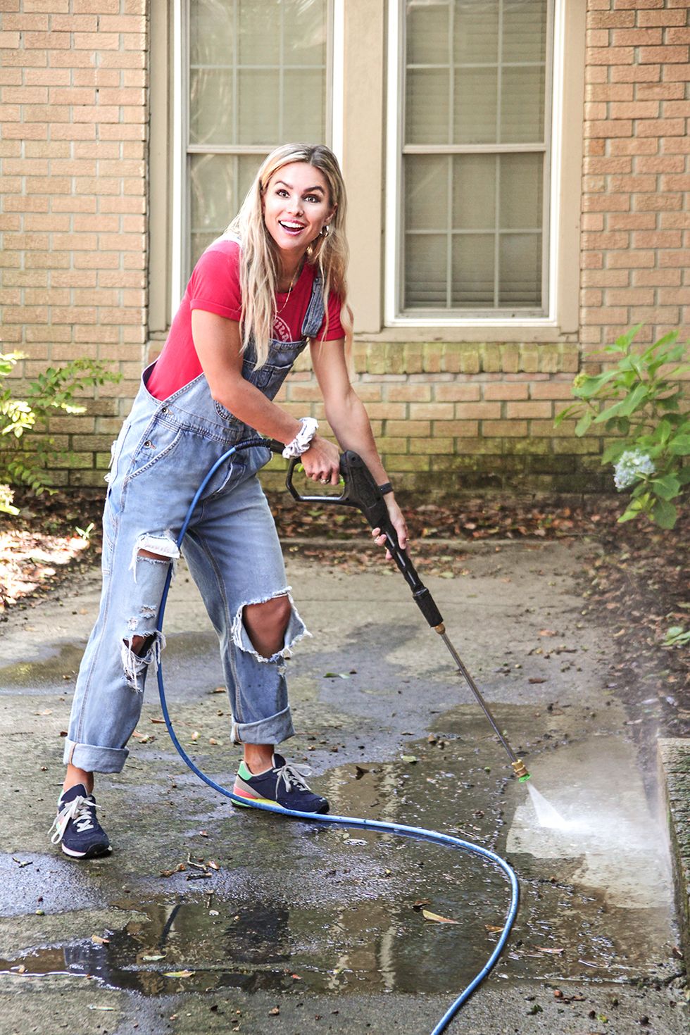show host mary welch power washes homeowners nico and erika sprotti's exterior walls, which she plans to paint a brighter and more refreshing color, as seen on breaking bland, season 1