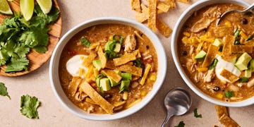 copycat chickfila chicken tortilla soup topped with tortilla strips, cilantro, avocado, and sour cream