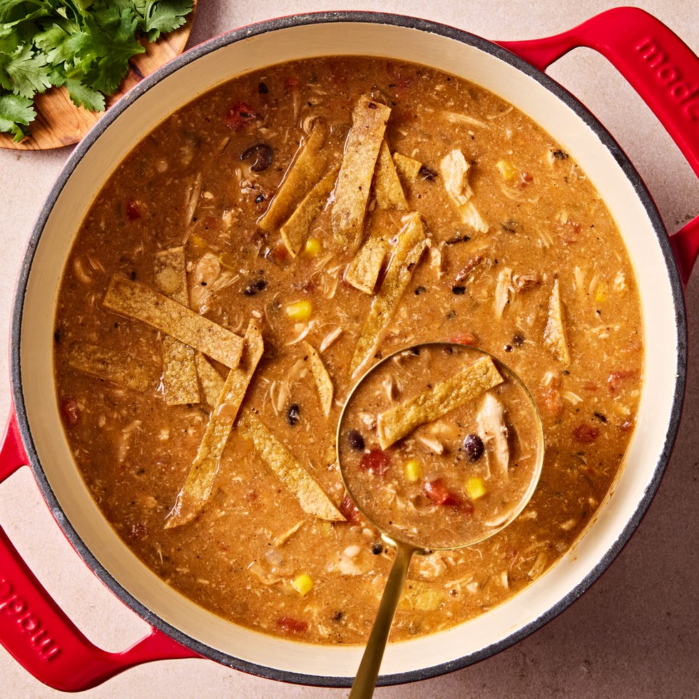 copycat chickfila chicken tortilla soup topped with tortilla strips, cilantro, avocado, and sour cream