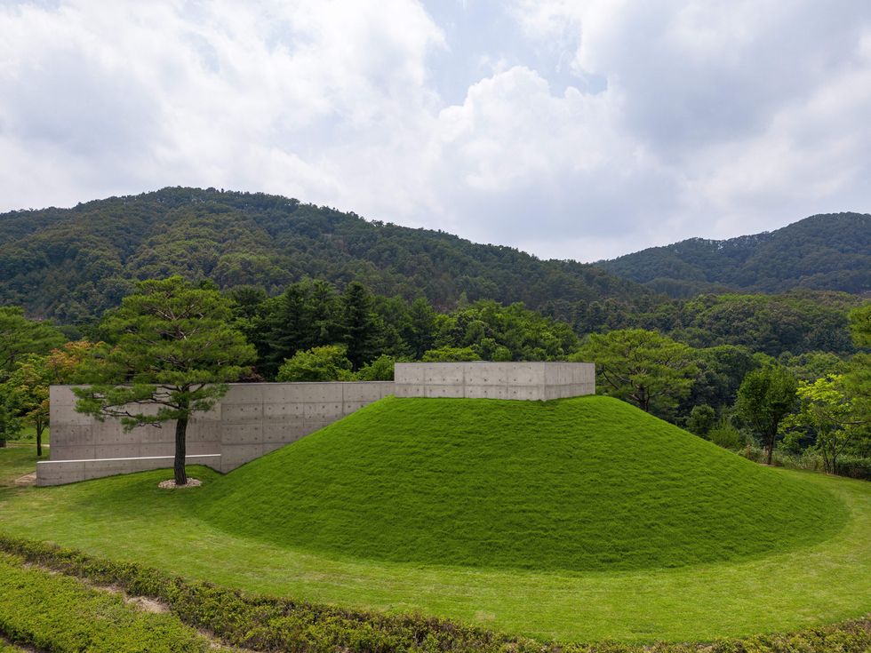 a chapel immersed in greenery and surrounded by mountains