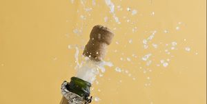 Cork exploding from champagne bottle
