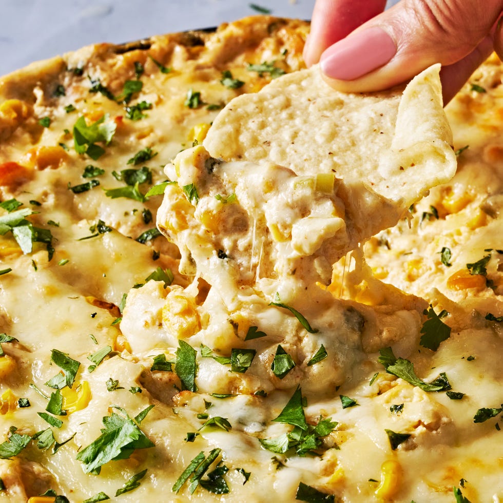 hot creamy corn dip in a cast iron skillet with tortilla chips