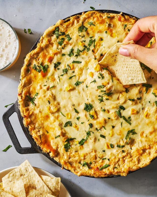 hot creamy corn dip in a cast iron skillet with tortilla chips