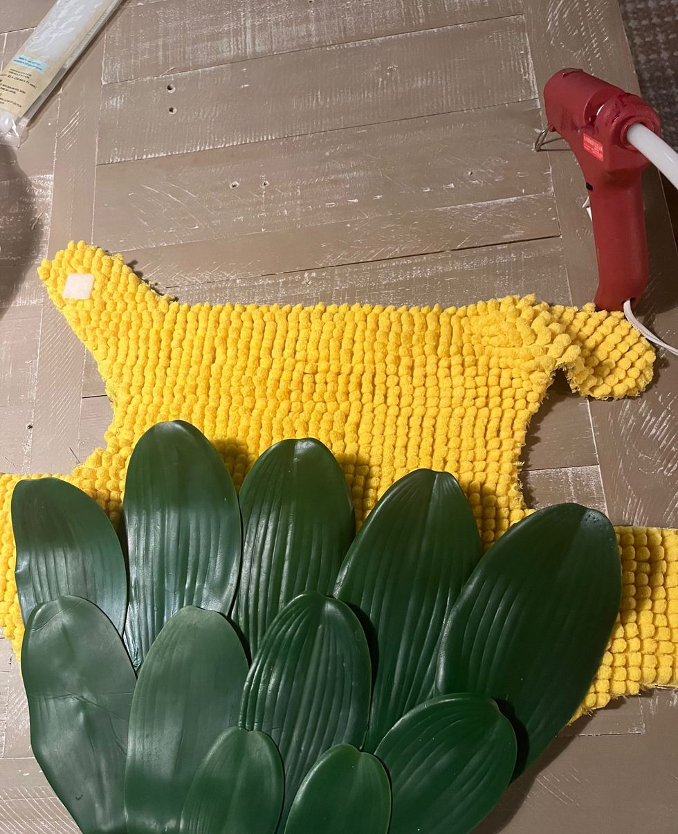 a picture of a dog costume in process of making that looks like a corn on the cob with husks