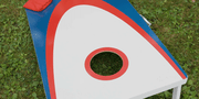 bean bag dropping into hole of corn hole game