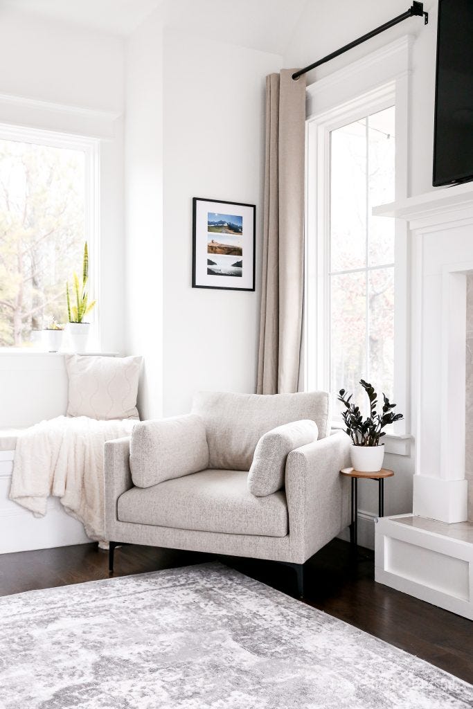 cozy living space featuring a chair plants and framed photos on the wall