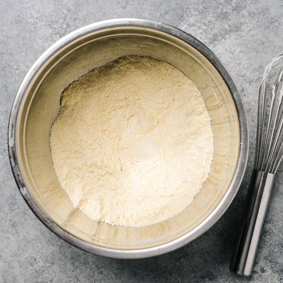 Cornmeal mix in a stainless steel bowl with a wire whisk cornmeal mix in a stainless steel bowl with a wire whisk