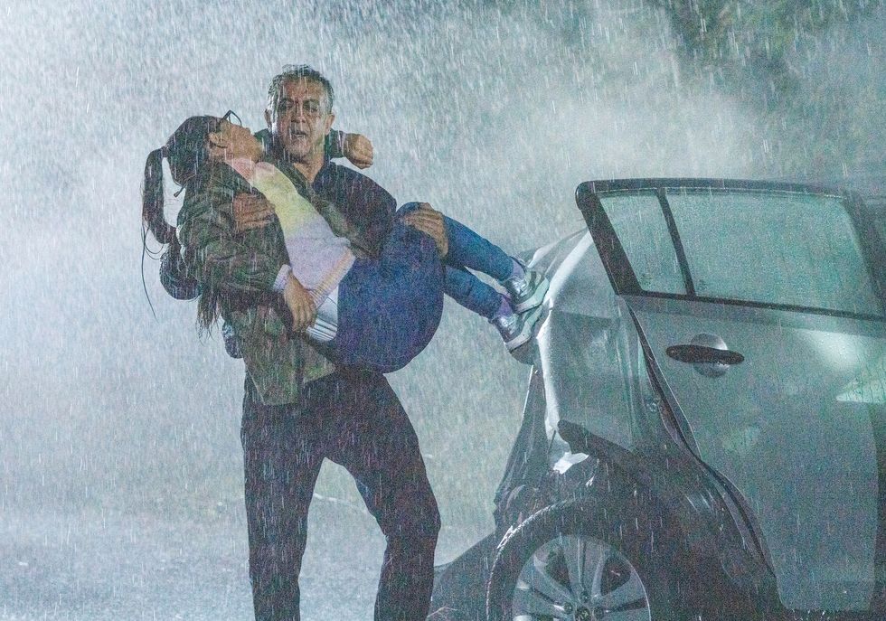 dev carries asha alahan from a car in torrential rain