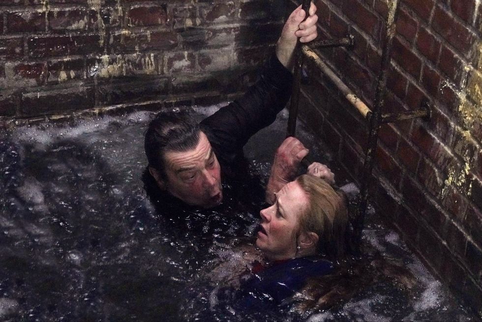 jenny and johnny connor in a flooded tunnel with heads above water and holding onto a ladder