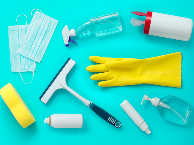 cleaning and disinfection tools and products on coloured background flay lay view