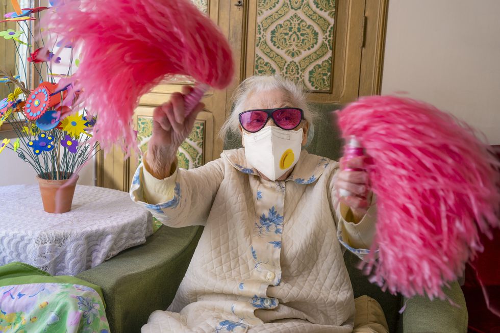 coronavirus covid 19 pandemic confinement with mask an humor cheerleader pom pom elderly woman happy