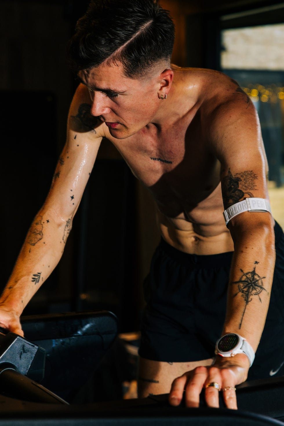 person exercising on a treadmill showcasing physical fitness and tattoos