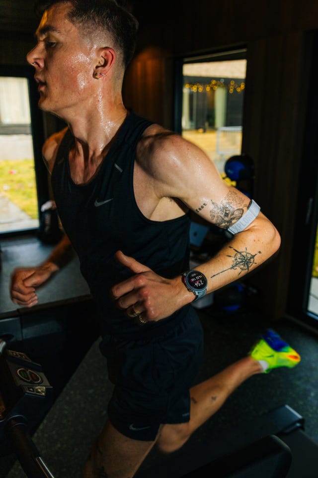 person running on a treadmill in athletic attire with tattoos visible on arms