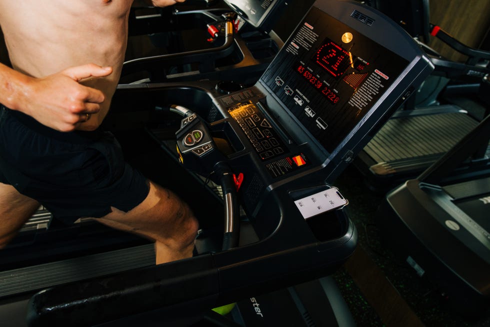 individual running on a treadmill displaying workout metrics