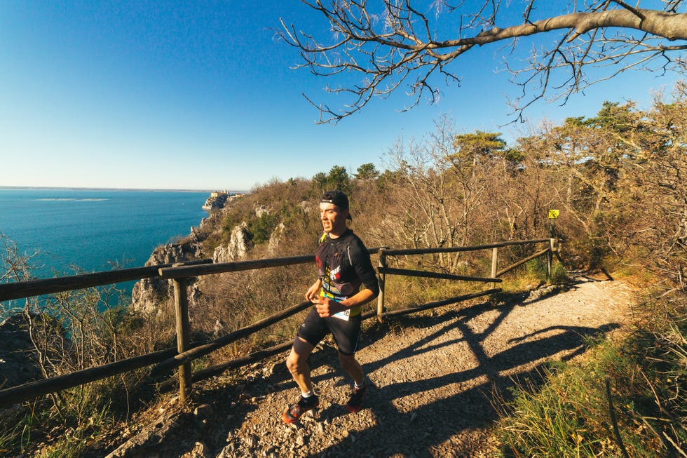 a man sitting on a fence by a body of water