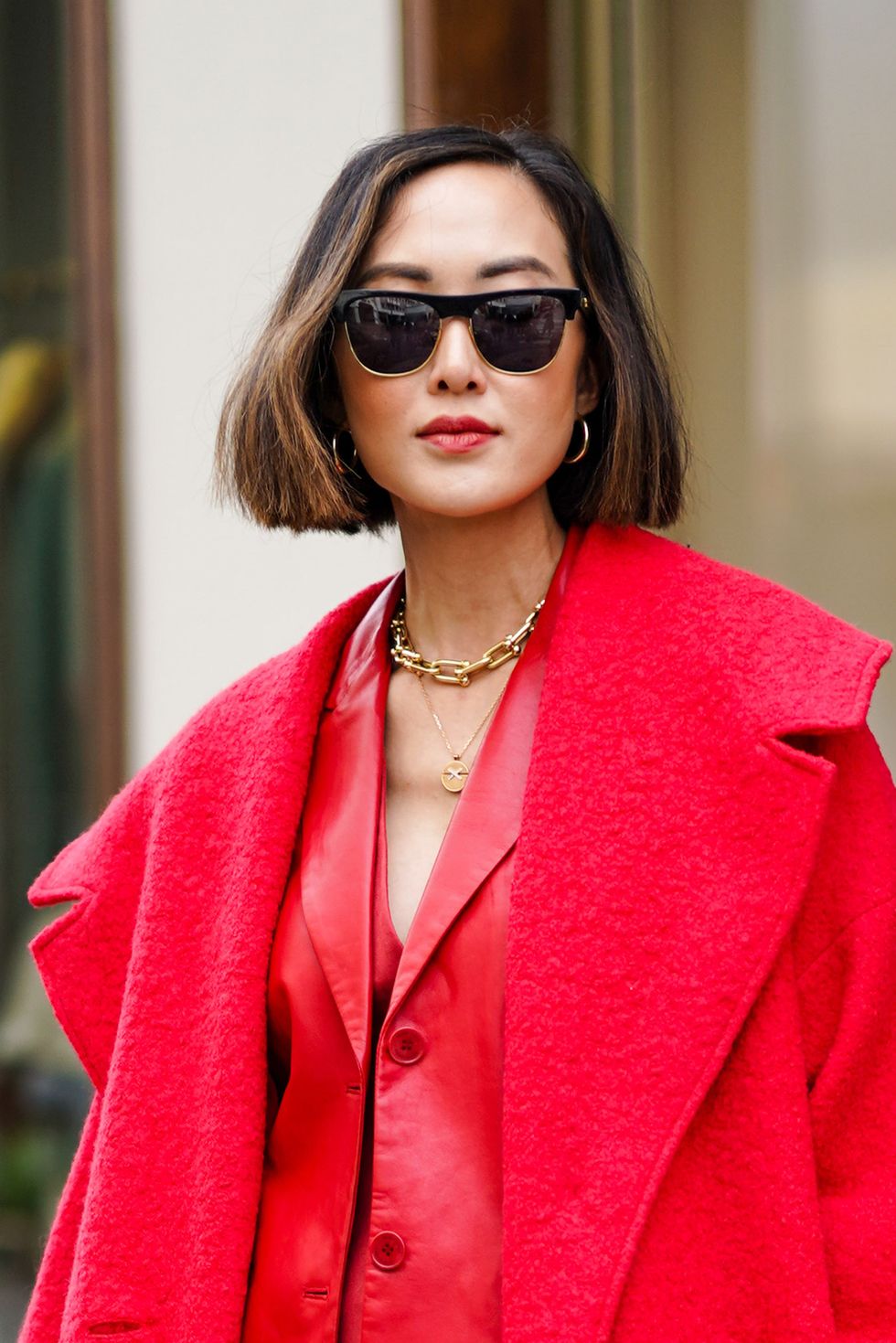 paris, france   february 29 chriselle lim wears sunglasses, a red long wool coat, a red jacket, a red skirt, burgundy leather pointy boots, a golden chain neklace, earrings, outside altuzarra, during paris fashion week   womenswear fallwinter 20202021, on february 29, 2020 in paris, france photo by edward berthelotgetty images