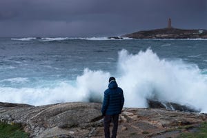 un hombre observa la torre de hércules en la coruña