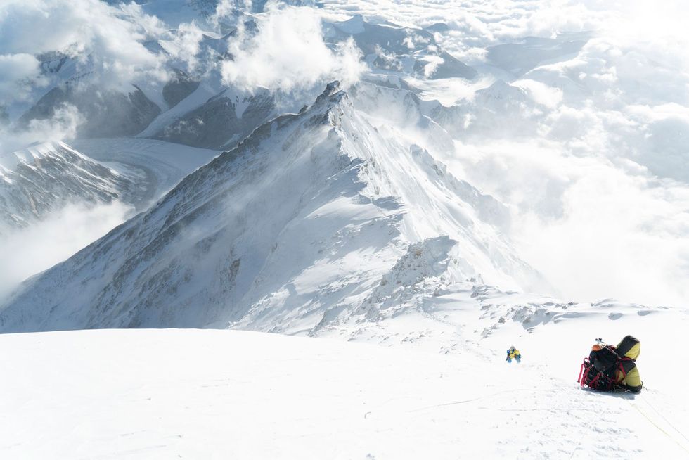 Op de Noordflank van de Everest bestijgen klimmers de laatste sneeuwpiramide op weg naar de top De hele Noordoostgraat en de route die eroverheen loopt zijn op de foto te zien Dit is een van de mogelijke secties van de beklimmings en afdalingsroute waarover Richards en Mena nog een besluit moeten nemen De eenvoudigste manier zou zijn om op het hoogste punt van hun beoogde nieuwe klimroute op de Noordoostflank aan te laten sluiten op de standaardroute en vervolgens gebruik te maken van de vaste zekeringstouwen op het laatste gedeelte van de klim van 8500 meter hoogte tot de top Een andere mogelijkheid is om hun nieuwe lijn op de Everest over een langere afstand voort te zetten door een segment van de Noordflank over te steken en uit te komen bij de Grand Couloir