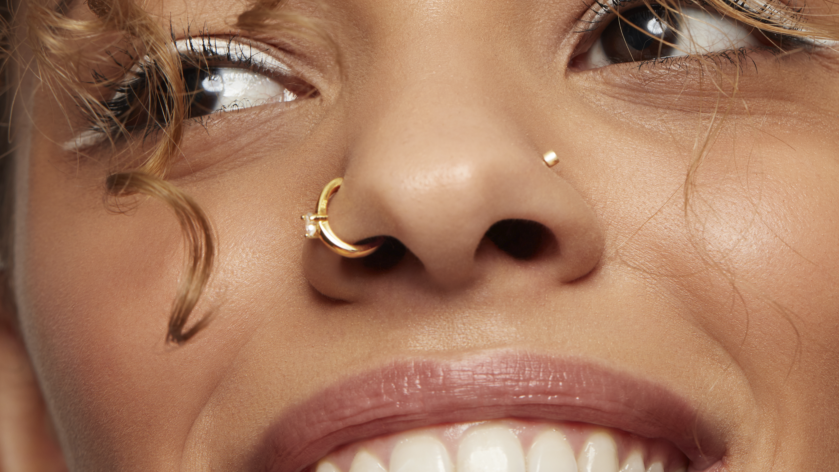 concept shoot with a model wearing a jewellery gold nose ring with chain at  a studio Stock Photo - Alamy