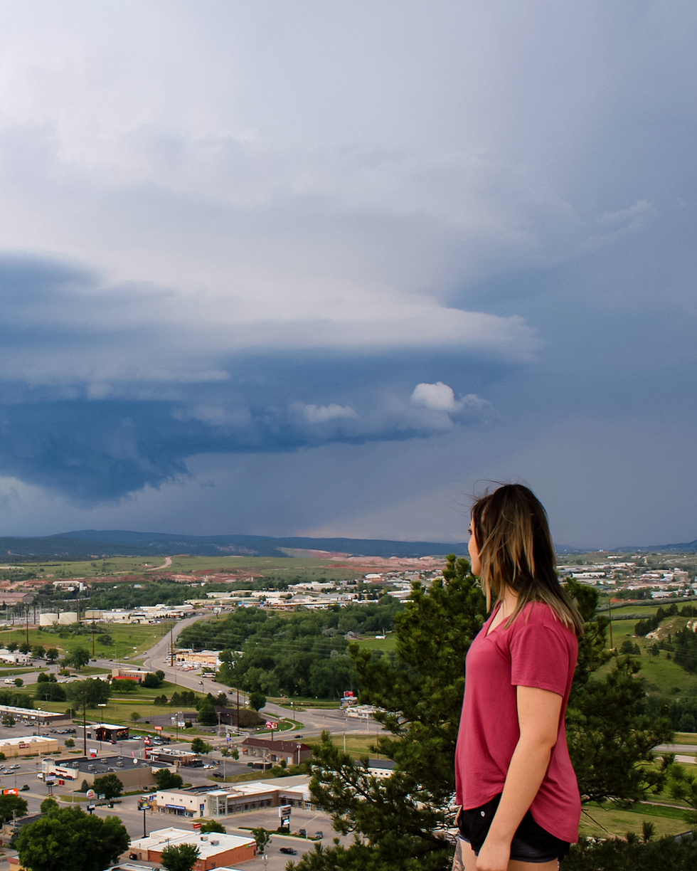 woman watches storm from a distance