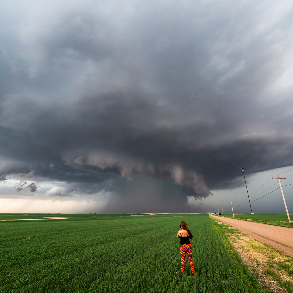 woman storm watching in field