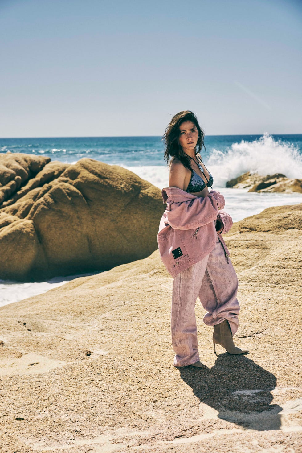 woman in pink denim standing on beach