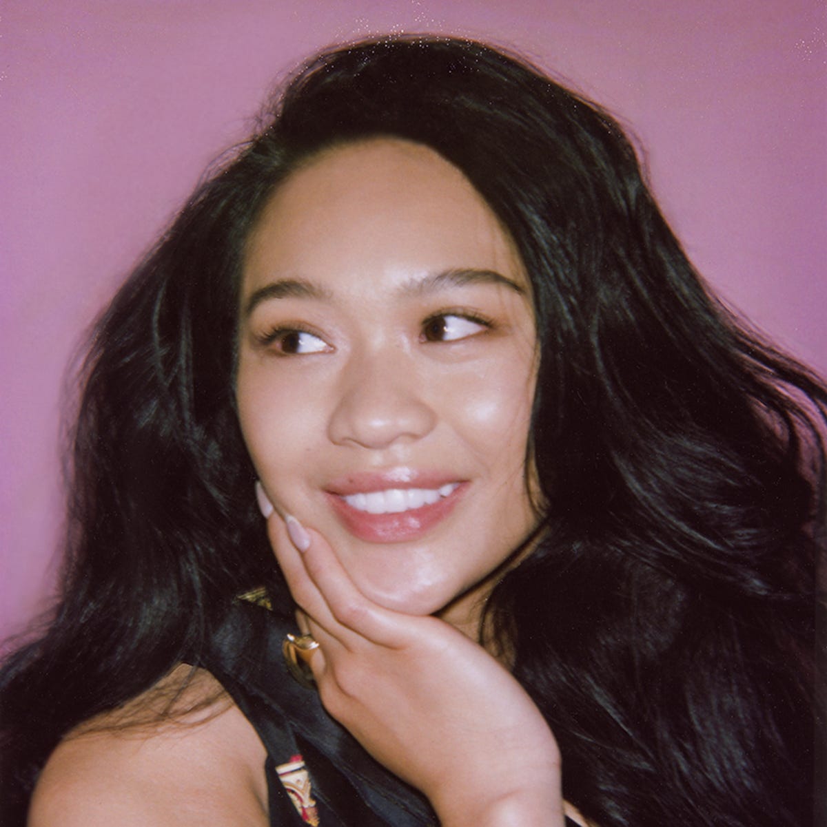 portrait with a blurred face against a pink background showcasing long hair and a hand gesture portrait with a blurred face against a pink background showcasing long hair and a hand gesture