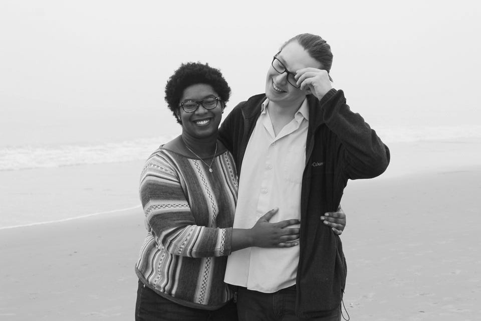 a couple embracing on a beach surrounded by fog