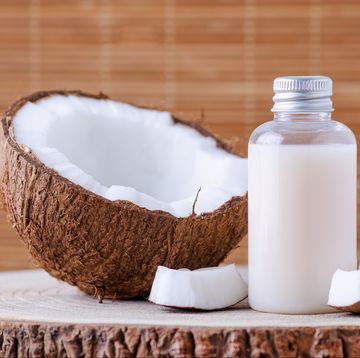 cosmetic bottle and fresh organic coconut for skincare, natural background