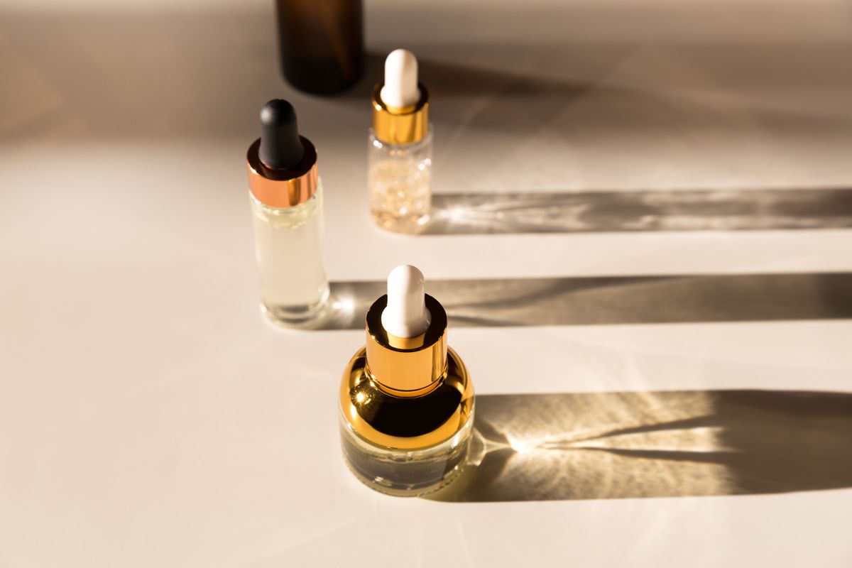 cosmetic serum bottle with a pipette in harsh light harsh shadows