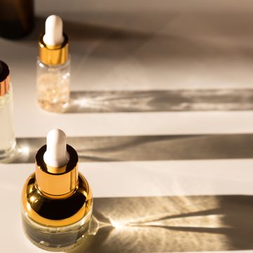 cosmetic serum bottle with a pipette in harsh light harsh shadows