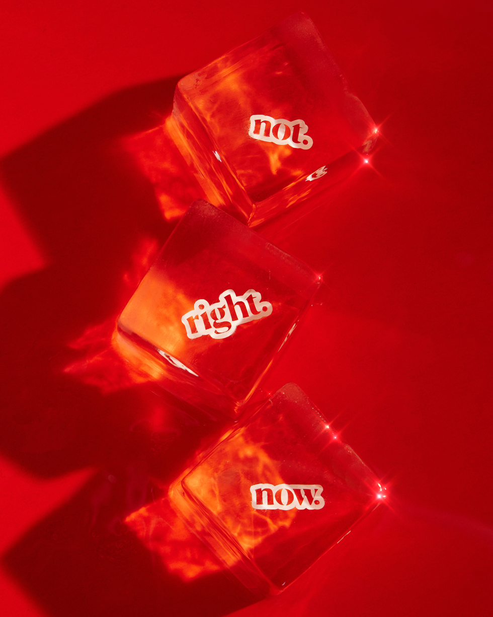 three ice cubes with the words "not right now" stacked on a red background