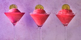pink frozen cosmo in a glass with a lime circle