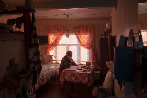 Vladimir 76 inwoner van Vladimir zit aan de telefoon in zijn huis
