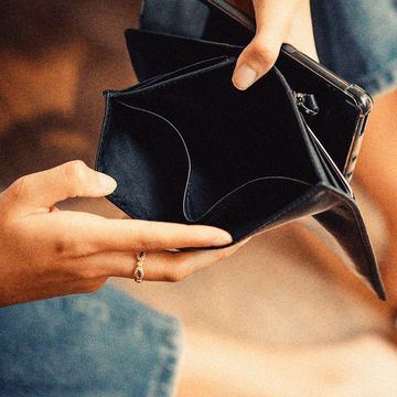 womans hands holding open an empty wallet