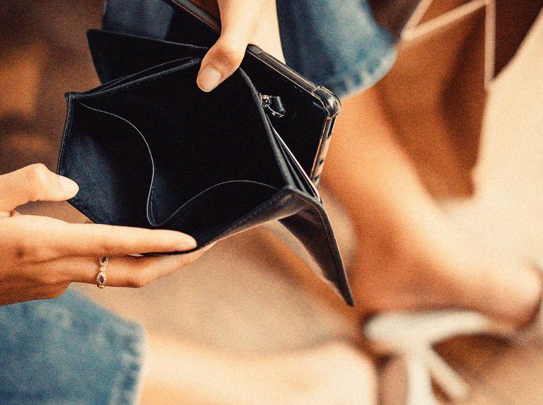 womans hands holding open an empty wallet