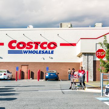 fairfax people with shopping carts filled with groceries goods, products walking out of costco store in virginia in parking car lot