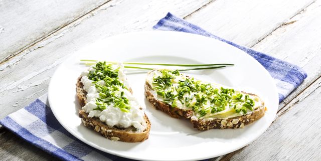 Cottage cheese, butter and chives on whole grain bread, close up